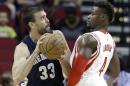 Memphis Grizzlies' Marc Gasol (33) pushes Houston Rockets' Jeff Adrien (4) in the first half of an NBA exhibition basketball game Thursday, Oct. 9, 2014, in Houston