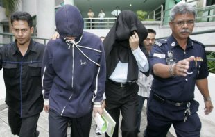 File photo of ex-policemen Azilah Hadri and Sirul Azhar Umar (heads covered). The Court of Appeal in Putrajaya on August 23, 2013 overturned their conviction of murdering Mongolian model Altantuya Shaariibuu. — Reuters pic