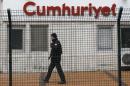 A private security employee stands guard at the   entrance of daily newspaper Cumhuriyet's offices, in Istanbul