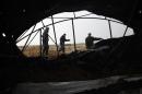 Members of the Palestinian security forces loyal to Hamas inspect the damage after Israeli air strikes on smuggling tunnels in Rafah