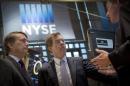 Kansas Governor Sam Brownback talks with a trader work on the floor of the New York Stock Exchange
