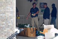 Authorities investigate a crime scene at a house in Pleasant Grove, Utah, Sunday, April 13, 2014. According to the Pleasant Grove Police Department, seven dead infants were found in the former home of Megan Huntsman, 39. Huntsman was booked into jail on six counts of murder. (AP Photo/Daily Herald, Mark Johnston)