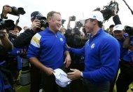 Team Europe golfer Jamie Donaldson (L) celebrates with teammate Rory McIlroy after winning his match against U.S. player Keegan Bradley to retain the Ryder Cup for Europe on the 15th green during the 40th Ryder Cup at Gleneagles in Scotland September 28, 2014. REUTERS/Eddie Keogh