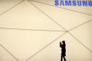 A woman takes a picture outside the Samsung stand at the Mobile World Congress in Barcelona