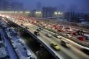 Cars drive along a bridge after snowfall in Urumqi