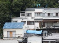 Policemen inspect the site (covered with blue sheets) where the dismembered body of a six-year-old Japanese girl Mirei Ikuta was found, who went missing on September 11, in Kobe, western Japan, on September 24, 2014