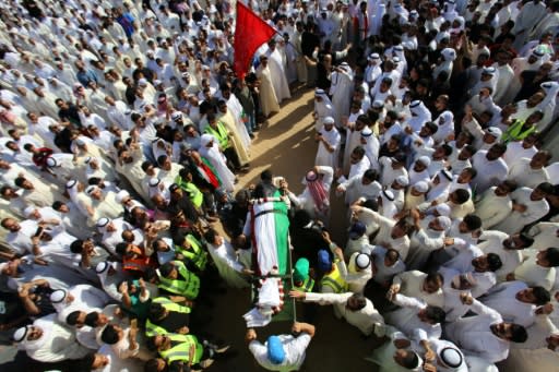 Mourners carry the body of one of the victims of the Al-Imam Al-Sadeq mosque bombing, during a mass funeral at Jaafari cemetery in Kuwait City on June 27, 2015