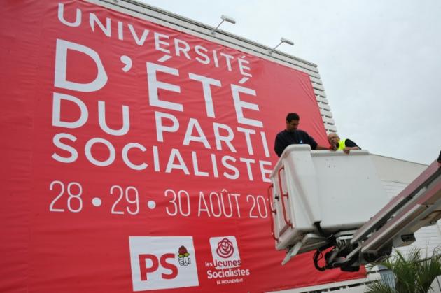 Des ouvriers installent une affiche pour l'Université d'été du PS à La Rochelle le 27 août 2015