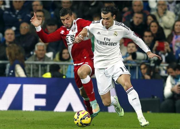 GRA301. MADRID, 08/11/2014.- El delantero galés del Real Madrid Gareth Bale (d) lucha un balón con el defensa argentino del Rayo Vallecano Emiliano Insúa (i), durante el partido de la undécima jornada