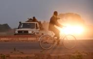 A man rides past gendarmes as they guard the road to the military barracks of the elite presidential guard on September 29, 2015 in Ouagadougou