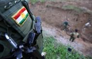 Un combatiente 'peshmerga' kurdo observando a dos compañeros, en Zumar, en Nínive (Irak), el 18 de diciembre de 2014, mientras siguen su lucha contra los combatientes del grupo Estado Islámico (EI)
