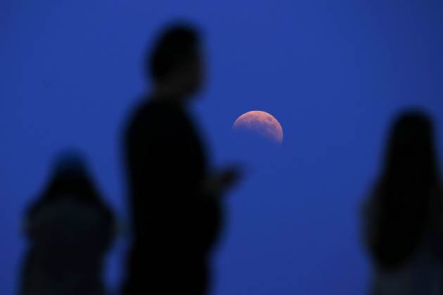 The beginning of a total lunar eclipse is seen from the Qizhong Tennis Court in Shanghai