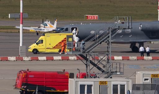 Medical staff in protective clothing transport a patient infected with the Ebola virus from a plane to an ambulance at Hamburg airport, northern Germany, on August 27, 2014