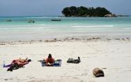 Turistas se bronzeiam na praia da ilha de Praslin, Seychelles, em 6 de março de 2012