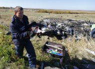 An Emergencies Ministry member walks near belongings and wreckage at the site where the downed Malaysia Airlines flight MH17 crashed, in Donetsk region, eastern Ukraine, October 13, 2014. Ukrainian search teams will comb the crash site of Malaysia Airlines flight MH17, which went down on July 17, and return human remains and belongings to the Netherlands, Dutch television reported. REUTERS/Shamil Zhumatov (UKRAINE - Tags: POLITICS CIVIL UNREST CONFLICT TRANSPORT)