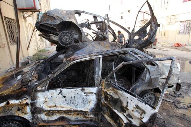 Un hombre examina vehículos quemados después de que estallara un coche bomba frente al concurrido barrio de Karrada, en Bagdad, el 2 de mayo de 2015
