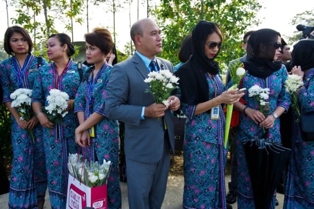 Malaysia Airlines flight attendants hold white flowers before the arrival of the Malaysian remains who perished aboard flight MH17 that was downed in eastern Ukraine outside Bunga Raya complex in Sepang today. – AFP pic, August 22, 2014.
