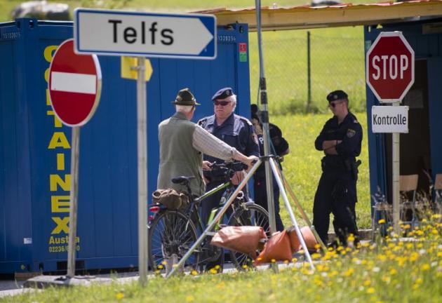 Un homme discute avec un policier à un point de contrôle sur la route menant à l'hôtel où se réunit le groupe Bilderberg, en Autriche, le 11 juin 2015