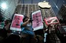 Defensores de los derechos humanos protestan coincidiendo con el lanzamiento de los nuevos iPhone 6, fuera de una tienda de Apple en Hong Kong el 25 de septiembre de 2015