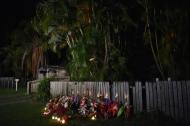 Flowers and stuffed toys are laid opposite the scene where eight children ranging from babies to teenagers were found dead in a house in the northern Australian city of Cairns early on December 20, 2014