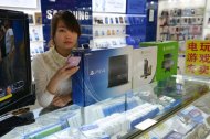Vendedora chinesa exibe PS4 e XBox One