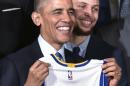 El presidente estadounidense, Barack Obama, posa con su camiseta de los Golden State Warriors junto al jugador Stephen Curry al recibir al equipo campeón de la pasada temporada de la NBA en la Casa Blanca, en Washington, el 4 de febrero de 2015