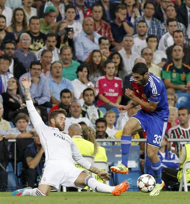 GRA591. MADRID. 16/09/2014.- El defensa del Real Madrid Sergio Ramos (i) lucha el balón con el centrocampista egipcio Mohamed Elneny (d), del FC Basilea, durante el partido de la primera jornada de la