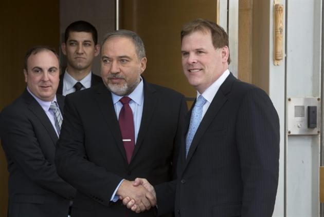 Israeli Foreign Minister Avigdor Lieberman, center left, shakes hands with his Canadian counterpart John Baird during their meeting in Jerusalem, Sunday, Jan. 18, 2015. Dozens of Palestinian protesters hurled eggs and shoes at the convoy of the visiting Canadian foreign minister Sunday in a show of defiance toward Canada's perceived pro-Israel stance. (AP Photo/Sebastian Scheiner)
