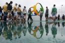 Aficionados caminan bajo la lluvia mientras se dirigen a las sedes de las actividades deportivas en el Parque Olímpico de los Juegos de Río de Janeiro, Brasil, el miércoles 10 de agosto de 2016. (AP Foto/Dmitri Lovetsky)