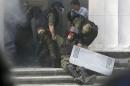 An injured national guard officer is carried away by   comrades outside the parliament building in Kiev
