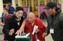 El ex preso político tibetano Palden Gyatso, de 85 años de edad, recibe ayuda para depositar su voto en la urna para elegir al Sikyong, el jefe del Gobierno tibetano en el exilio, en McLeod Ganj, India, el 20 de marzo de 2016