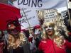 Mujeres enmascaradas sostienen mantas durante una marcha de prostitutas y de sus simpatizantes con el fin de protestar por los planes de cerrar los escaparates de la afamada Zona Roja de Amsterdam, Holanda, el jueves 9 de abril de 2015. (Foto AP/Peter Dejong)