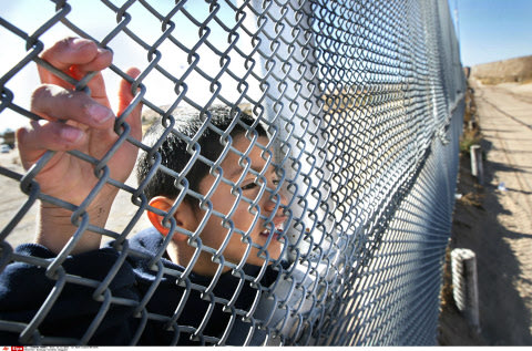 Un enfant regarde à travers le grillage de la frontière entre le Mexique et les Etats-Unis, le 24 décembre 2013., Mark Lambie/AP/SIPA