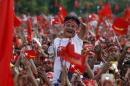 A supporter waves while Myanmar pro-democracy leader   Aung San Suu Kyi gives a speech at her campaign rally for up coming general   elections in Yangon