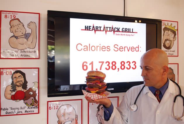 Jon, le propriétaire du "Crise cardique grill" pose avec un cheeseburger quadruple pontage à Chandler, situé en Arizona. Le restaurant est connu pour proposer des hamburgers triples et quadr