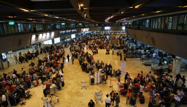 Passengers form a long line in front of airlines check in counters at the terminal building of Manila international airport on June 16, 2008