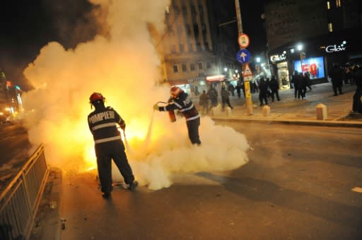 Romanian firefighters extinguish a fire in the center of Bucharest on January 15, 2012