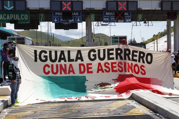 Students hold a banner for missing students, which reads Iguala Guerrero, Cuna de Asesinos, (Iguala Guerrero, Cradle of Murderers), during a demonstration demanding their safe return, at a tollbooth for Palo Blanco, to Acapulco, on the outskirts of Chilpancingo, in Guerrero, October 7, 2014. Mexican President Enrique Pena Nieto vowed on Monday to hunt down those responsible for the apparent massacre of dozens of students in the southwest of the country that authorities say involved local security officials. The students went missing after they clashed with police in Iguala in Guerrero on Sept. 26. A mass grave was found near the town over the weekend, full of charred human remains. Guerrero's attorney general, Inaky Blanco, said on Sunday that 28 bodies have been found at the site so far, and it is "probable" that some of the missing 43 students are among the remains found in the graves. REUTERS/Jorge Dan Lopez (MEXICO - Tags: POLITICS CIVIL UNREST EDUCATION CRIME LAW)