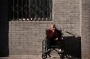 An elderly lady sits in a wheelchair in Beijing
