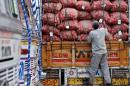 A labourer prepares to unload sacks of potatoes from   a truck at a wholesale vegetable and fruit market in New Delhi