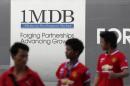 Men walk past a 1Malaysia Development Berhad (1MDB)   billboard at the fund's flagship Tun Razak Exchange development in Kuala   Lumpur