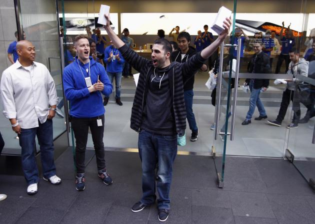 David Rahimi holds up his iPhone 6 and iPhone 6 Plus after he became the first customer to purchase them at the Apple store in Sydney