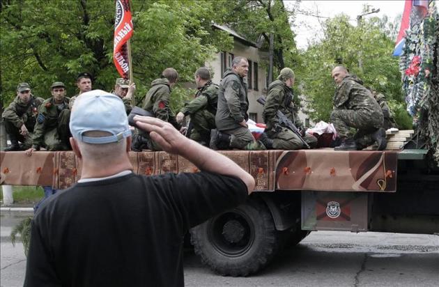 Un civil saluda al convoy de rebeldes prorrusos que transporta el ataúd con los restos mortales de Alexéi Mozgovói, jefe de una brigada de milicianos prorrusos, que murió la semana pasada en Alchevsk, en la región de Lugansk, Ucrania. EFE