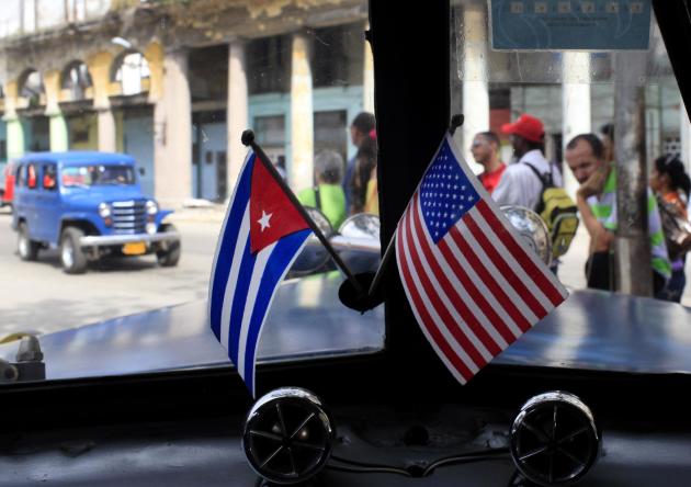 Fotografía de archivo del 22 de marzo de 2013 de dos pequeñas banderas de Cuba y Estados Unidos sobre el tablero de instrumentos de un automóvil en La Habana, Cuba. (Foto AP/Franklin Reyes, Archivo)