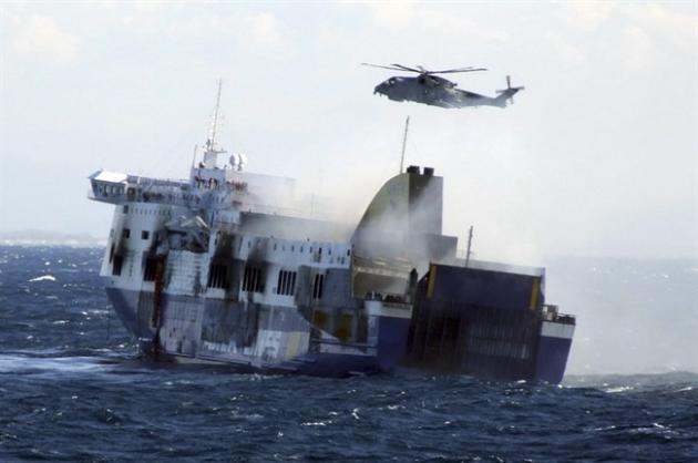 In this image released by the Italian Navy, smoke billows from the Italian-flagged Norman Atlantic that caught fire in the Adriatic Sea, Monday, Dec. 29, 2014. Fighting high winds and stormy seas, helicopter rescue crews on Monday evacuated the last of hundreds of people trapped aboard a Greek ferry that caught fire off Albania. The death toll climbed to eight as survivors told of a frantic rush to escape the flames and pelting rain. The evacuation of the ferry was completed in the early afternoon with the rescue of 427 people, including 56 crew members, said Italy's transport minister, Maurizio Lupi. The original ferry manifest listed 422 passengers and 56 crew members, but Lupi said it was premature to speculate on whether people were still missing. He suggested that there might have been some people who reserved a spot on the ferry but did not board. (AP Photo/Italian Navy, ho)