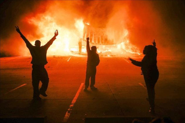 Manifestantes protestan ante un edificio en llamas durante los disturbios en Ferguson, Misuri, Estados Unidos, después de que el fiscal anunciara que un gran jurado había decidido no imputar al policía Darren Wilson por la muerte del joven Michael Brown. EFE