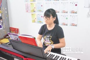 14歲的蕭貞翎，從小就夢想有部鋼琴，但因家境清寒，只能自繪「紙鋼琴」努力練習。移民署長莫天虎昨擔任圓夢大使，前往贈送電子鋼琴，一圓她的鋼琴夢。（譚宇哲攝）