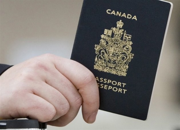 A passenger holds his Canadian passport before boarding a flight in Ottawa on Jan 23, 2007. A human rights lawyer is raising concern about the federal government's plan to strip Canadian passports of those suspected of travelling abroad to join extremist groups THE CANADIAN PRESS/Tom Hanson