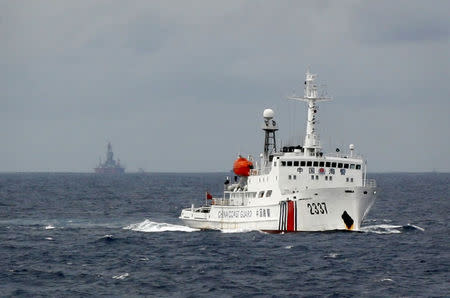 A Chinese Coast Guard vessel (R) passes near the Chinese oil rig, Haiyang Shi You 981 (L) in the South China Sea, about 210 km (130 miles) from the coast of Vietnam June 13, 2014. REUTERS/Nguyen Minh