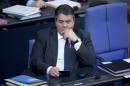 Germany's Economy Minister Gabriel holds a phone during a debate at the lower house of parliament Bundestag in Berlin